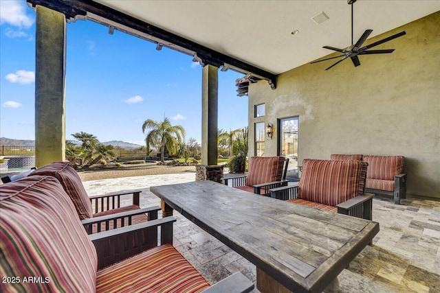 view of patio featuring ceiling fan, an outdoor hangout area, and a mountain view