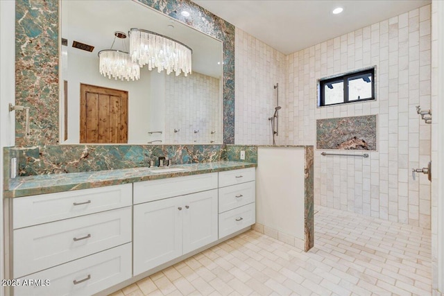 bathroom with vanity, decorative backsplash, and a tile shower