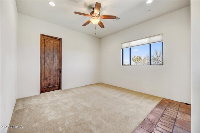 spare room featuring ceiling fan and light colored carpet