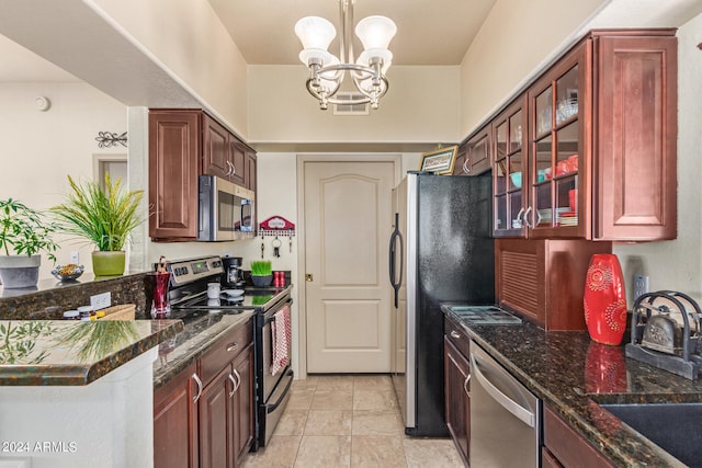 kitchen with sink, hanging light fixtures, dark stone countertops, a chandelier, and appliances with stainless steel finishes