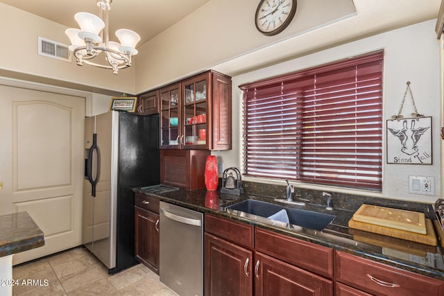 kitchen with pendant lighting, an inviting chandelier, sink, dark stone countertops, and stainless steel appliances