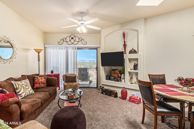 living room featuring ceiling fan, carpet floors, and a skylight