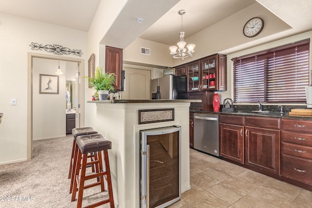 kitchen featuring sink, stainless steel appliances, pendant lighting, light colored carpet, and a breakfast bar