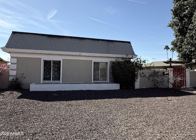 back of property with fence and stucco siding