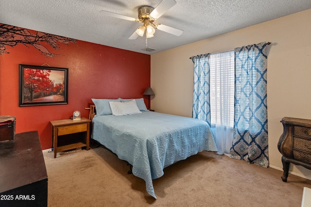 bedroom with carpet floors, ceiling fan, visible vents, and a textured ceiling