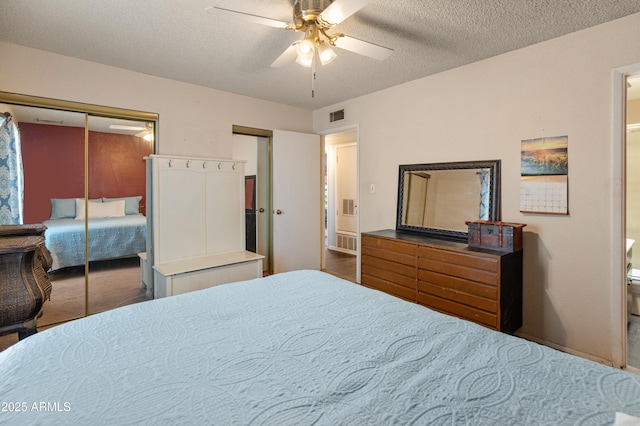 bedroom with a textured ceiling, ceiling fan, and visible vents