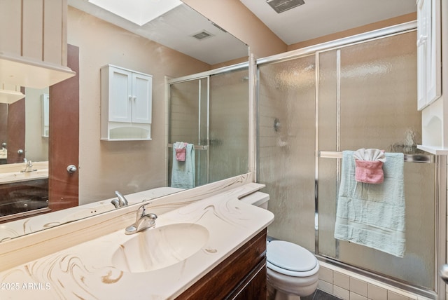 bathroom with a skylight, visible vents, a shower stall, and toilet