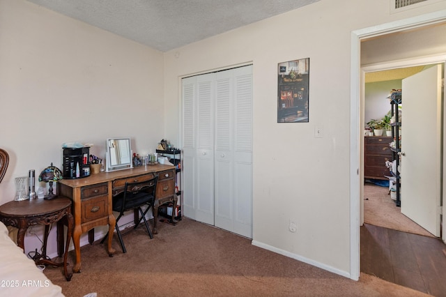 carpeted home office featuring a textured ceiling and baseboards