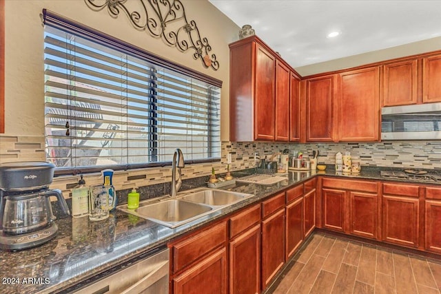 kitchen featuring decorative backsplash, sink, stainless steel appliances, and hardwood / wood-style flooring