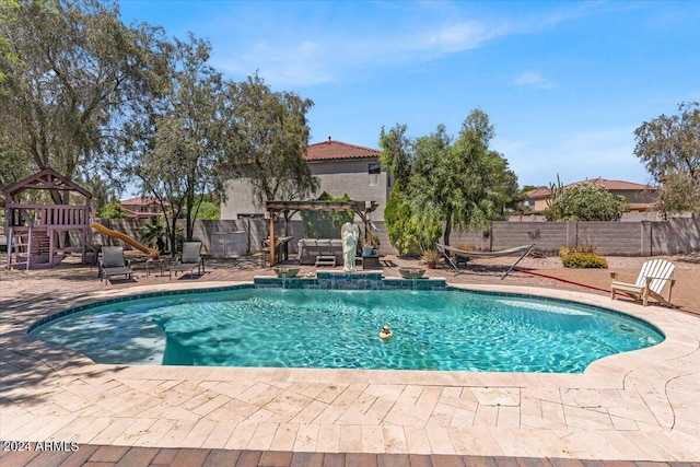 view of pool with pool water feature, a playground, and a patio