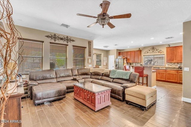 living room featuring light wood-type flooring and ceiling fan