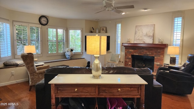 living room featuring dark wood-type flooring, ceiling fan, and a brick fireplace