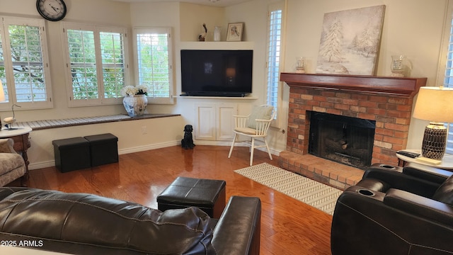 living room with hardwood / wood-style floors and a brick fireplace