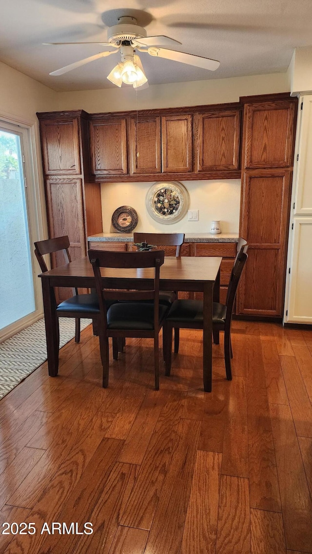 dining room with dark wood-type flooring and ceiling fan