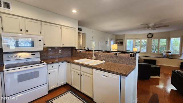 kitchen with sink, white cabinets, dark hardwood / wood-style flooring, kitchen peninsula, and white appliances