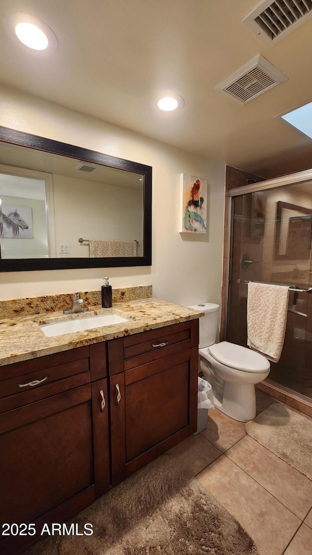 bathroom with tile patterned flooring, vanity, toilet, and a shower with shower door