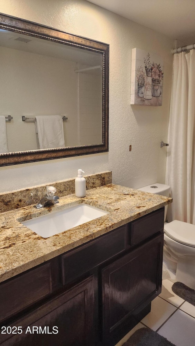 bathroom with vanity, tile patterned flooring, and toilet