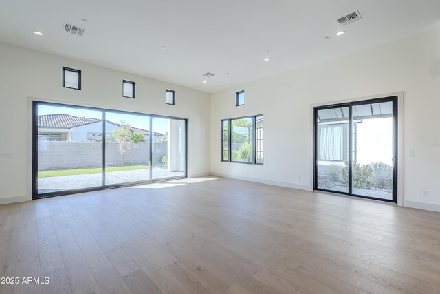 unfurnished living room with light wood-style flooring, baseboards, and recessed lighting