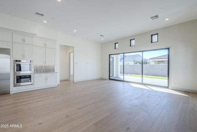 unfurnished living room featuring light wood-style floors, recessed lighting, and baseboards