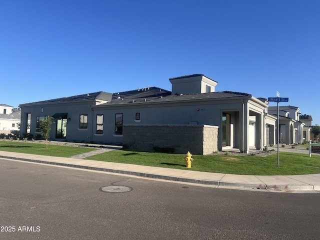 view of home's exterior featuring an attached garage, stucco siding, and a yard