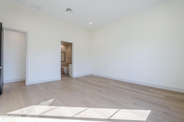 spare room featuring light wood finished floors, baseboards, and recessed lighting