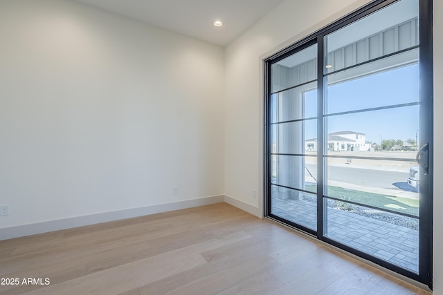 spare room featuring light wood-style flooring, baseboards, and recessed lighting