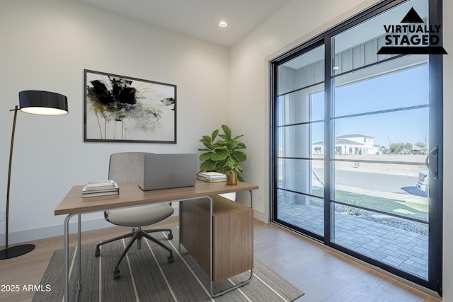 office space with light wood-style floors, recessed lighting, and baseboards