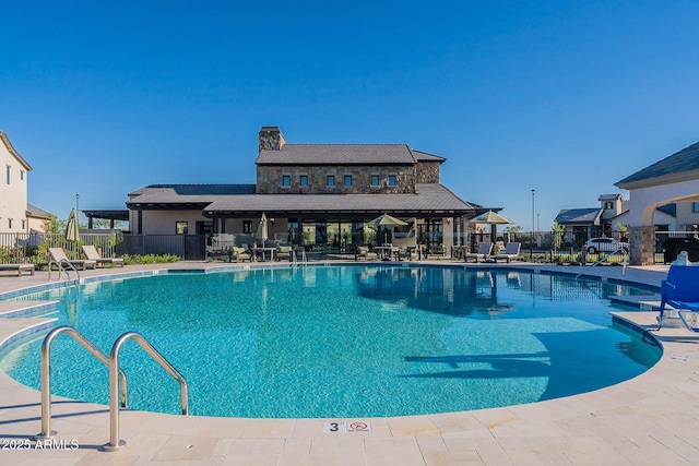 community pool featuring fence and a patio area