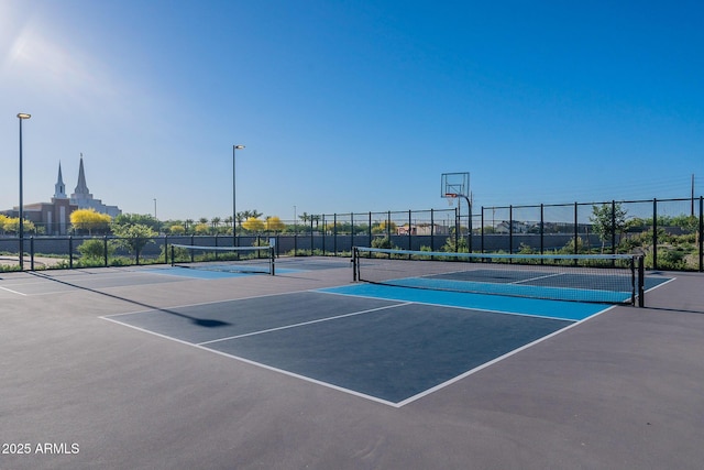 view of tennis court with fence and community basketball court