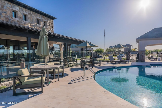 community pool with fence and a patio