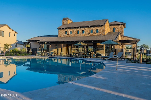community pool featuring fence and a patio