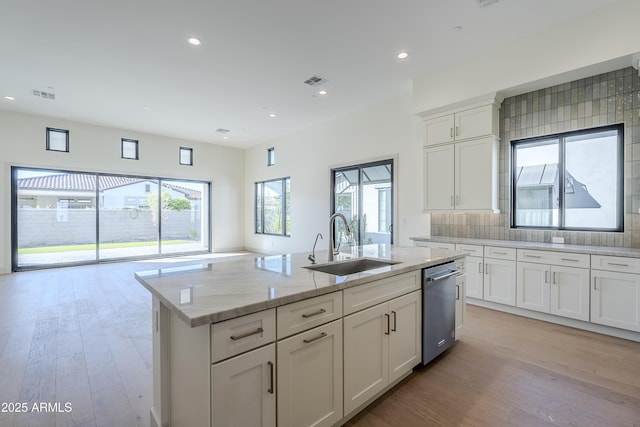 kitchen with a sink, dishwasher, light wood-style floors, a kitchen island with sink, and recessed lighting