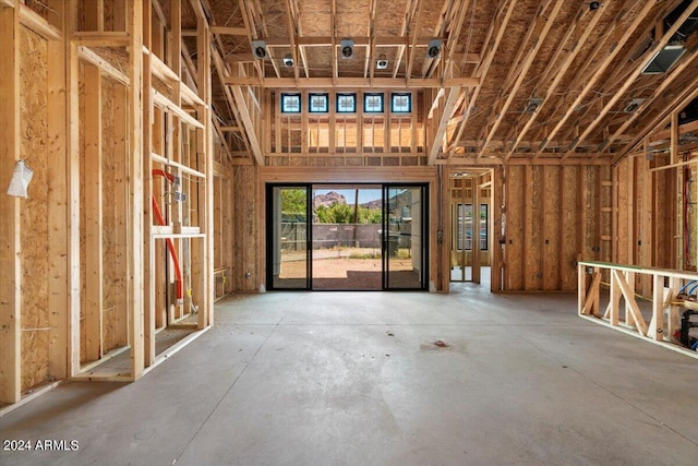 miscellaneous room with concrete flooring and a towering ceiling