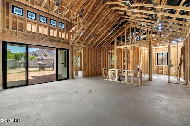 miscellaneous room with concrete flooring and a towering ceiling