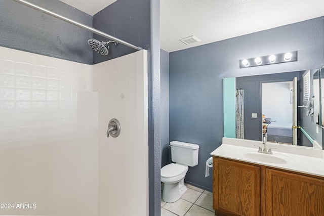 bathroom with walk in shower, vanity, tile patterned flooring, and toilet