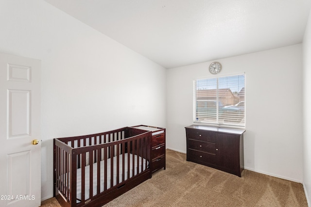 carpeted bedroom with a nursery area