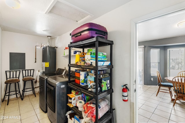 laundry room with water heater, light tile patterned floors, and washing machine and dryer