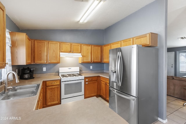 kitchen featuring light tile patterned floors, sink, white gas range, stainless steel fridge with ice dispenser, and vaulted ceiling