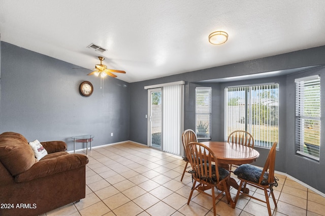 dining space featuring a textured ceiling, light tile patterned floors, ceiling fan, and plenty of natural light