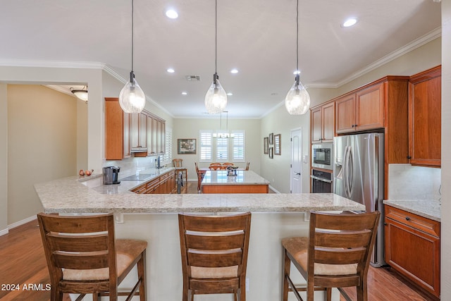 kitchen with tasteful backsplash, kitchen peninsula, light hardwood / wood-style floors, and appliances with stainless steel finishes