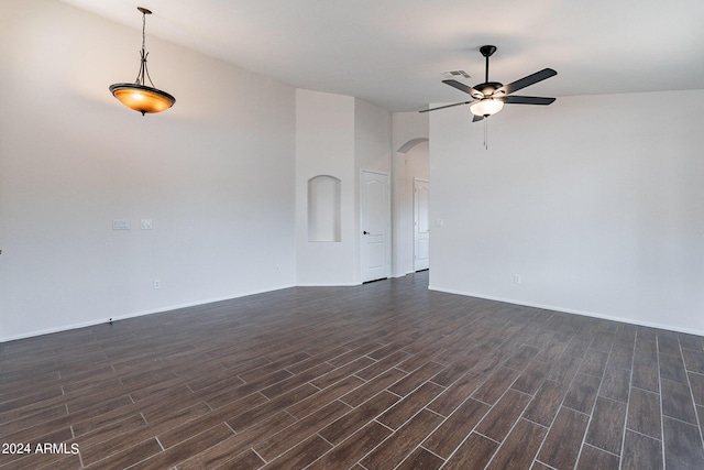 unfurnished room featuring dark wood-type flooring and ceiling fan