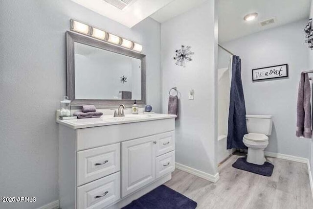 full bath featuring toilet, baseboards, wood finished floors, and vanity