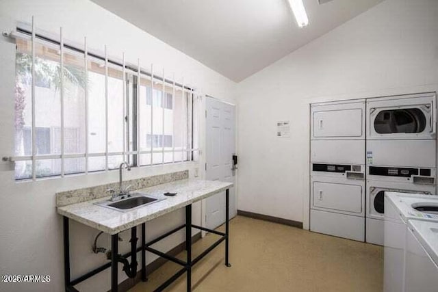 community laundry room featuring baseboards, stacked washer / drying machine, and a sink