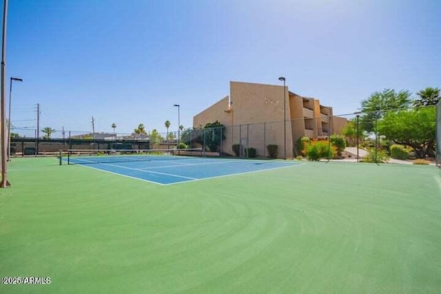 view of tennis court featuring fence