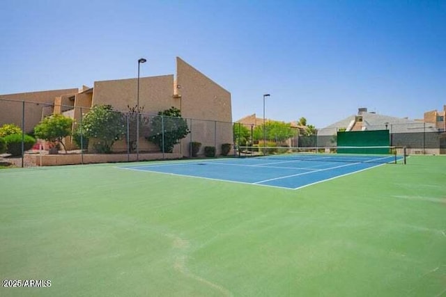 view of tennis court featuring fence