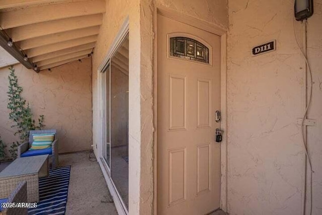 doorway to property featuring stucco siding