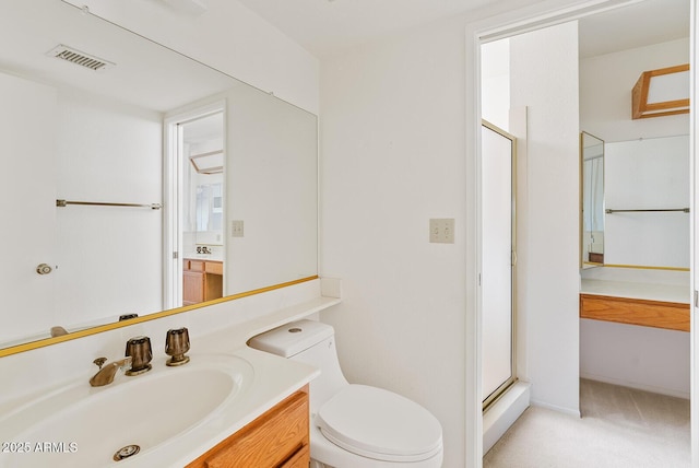 bathroom featuring toilet, a shower stall, visible vents, and vanity