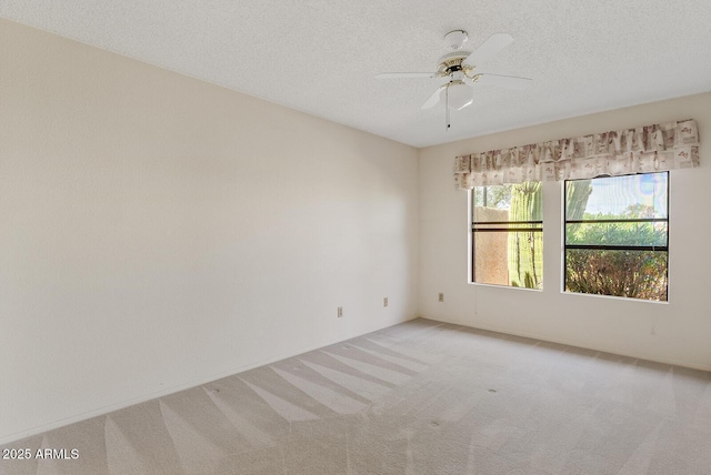 unfurnished room with ceiling fan, a textured ceiling, and light colored carpet