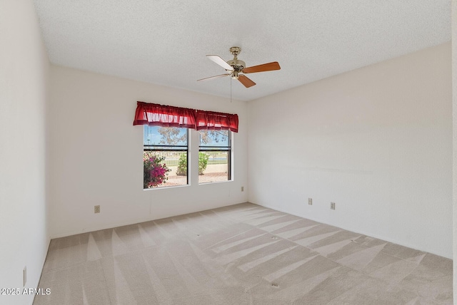 carpeted spare room with a textured ceiling and ceiling fan