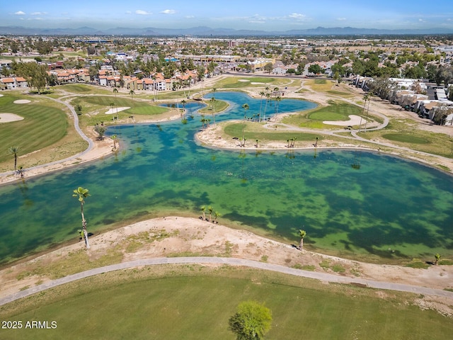 drone / aerial view featuring golf course view, a water view, and a residential view